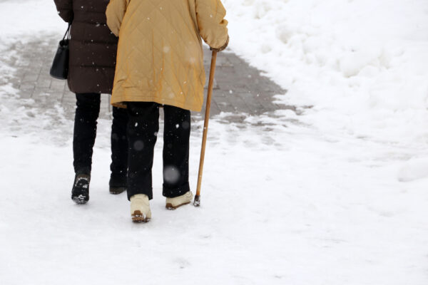 older couple with joint pain walking in the snow